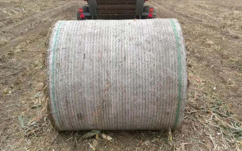 Round bales wrapped with Silopak net wrap stacked in the field after harvest